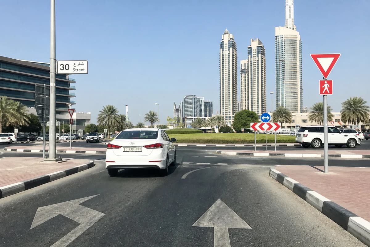 Rental vehicle navigating multi lane Dubai roundabout with proper lane discipline